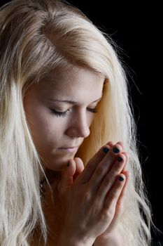 young woman praying, closed eyes