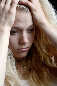 unhappy young blond woman with hands on head