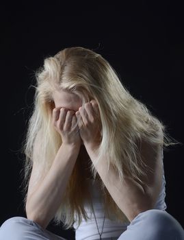 unhappy young woman in front of black background