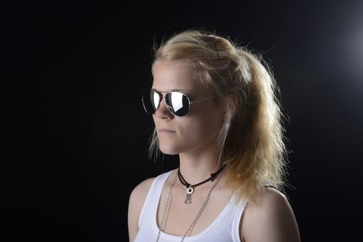 young blond woman with sunglasses against black background