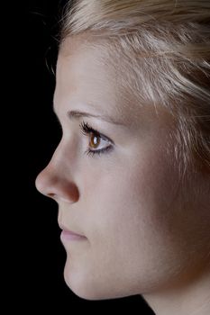 young blond woman in front of black background