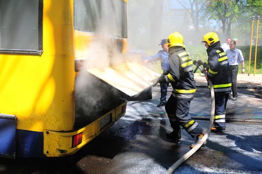 SERBIA, BELGRADE - APRIL 27, 2012: Fire fighters tries to extinguish burning bus on the street