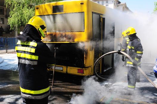 SERBIA, BELGRADE - APRIL 27, 2012: Fire fighters tries to extinguish burning bus on the street