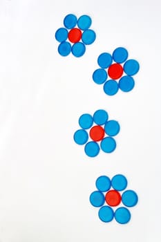 The red and blue circle plastic pieces are arrange  in the shape of flowers.