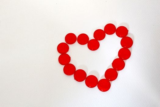 Many circle plastic pieces are arrange in the heart shape.