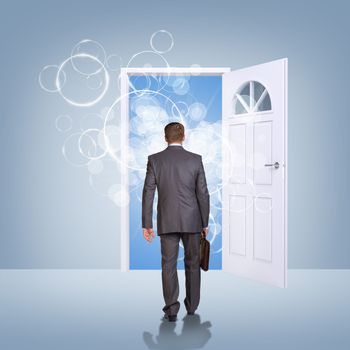 Businessman in suit with briefcase stepping through door. Sky as backdrop. Business concept