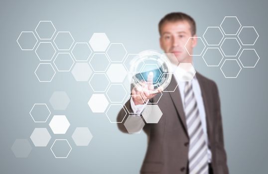 Businessman in suit finger presses virtual button. Transparent hexagons and glow circles as backdrop