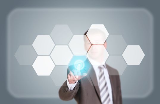 Businessman in suit finger presses virtual button. Transparent hexagons and glow circles as backdrop