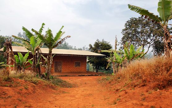 Typical African red clay or soil brick with tin roof house 