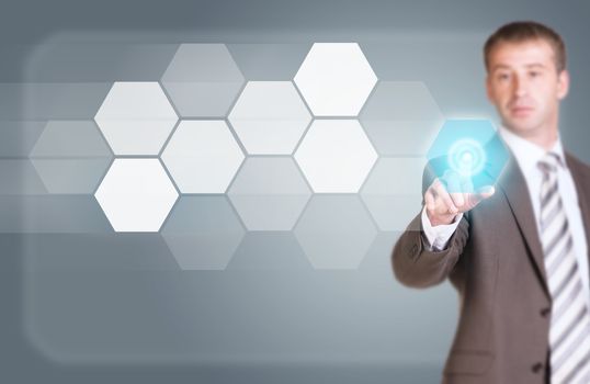 Businessman in suit finger presses virtual button. Transparent hexagons and glow circles as backdrop