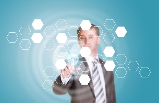 Businessman in suit finger presses virtual button. Transparent hexagons and glow circles as backdrop