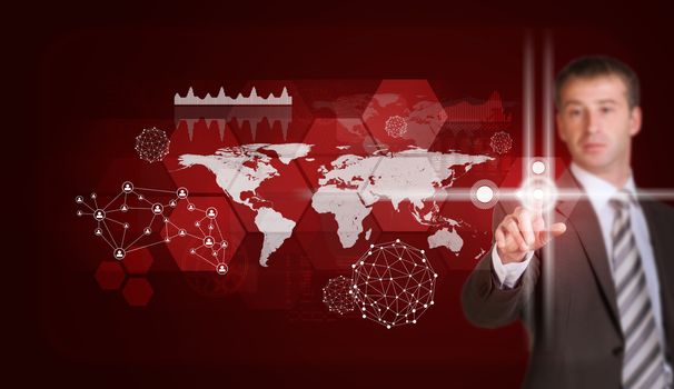 Businessman in suit finger presses virtual button. Graphs, world map, network and other elements as backdrop
