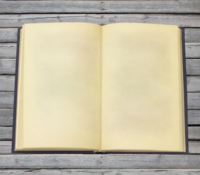 Old open book with blank pages. Gray wooden boards on background
