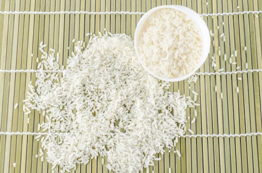 uncook rice in mini bowl on wooden pad