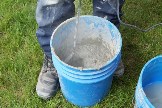 Man mixing cement with drill outside