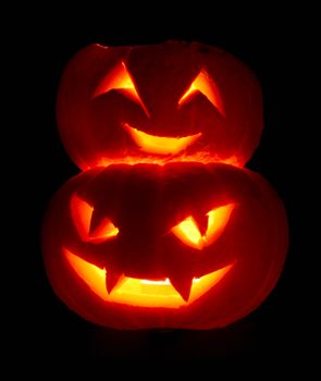 Illuminated cute halloween pumpkins isolated on black background