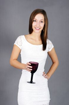 Beautiful natural young woman in white lace dress with drink smiling