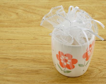 Ceramic flower taken as souvenirs, wrapped with white gauze tied with a white ribbon.