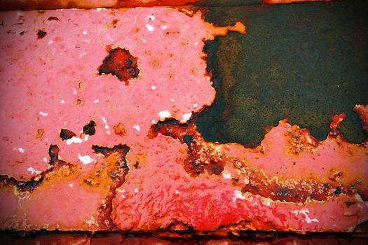 Macro of peeled red paint and rust on steel beam at a pier