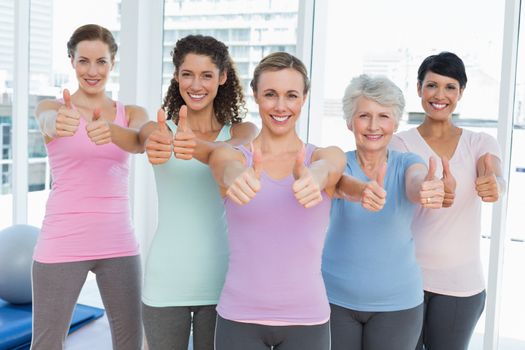 Portrait of smiling women gesturing thumbs up in the yoga class