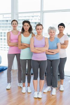 Portrait of confident women with arms crossed standing in the yoga class