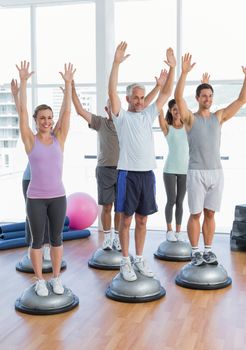 Full length portrait of smiling people doing power fitness exercise at yoga class