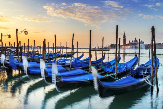 Gondolas moored by Saint Mark square with San Giorgio di Maggiore church in the background - Venice, Venezia, Italy, Europe 