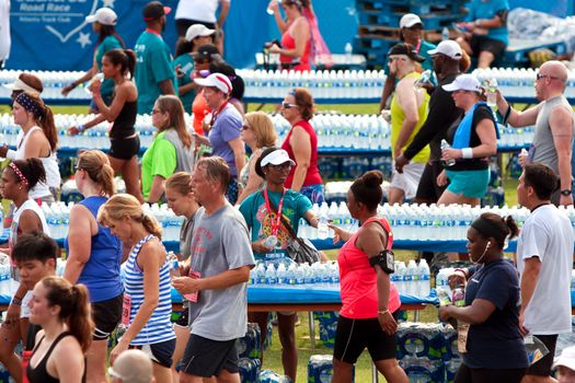 Atlanta, GA, USA - July 4, 2014:  Volunteers hand out water bottles to exhausted runners in the aftermath of the Peachtree Road Race 10K.  