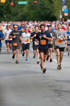 Atlanta, GA, USA - July 4, 2014:  Thousands of runners flow down an Atlanta street on their way to the finish line of the Peachtree Road Race.