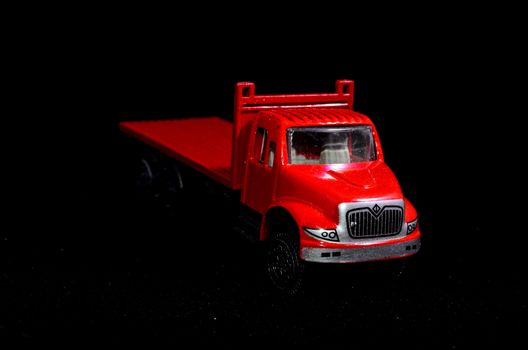 Red Toy Figurine Truck on a Black Background
