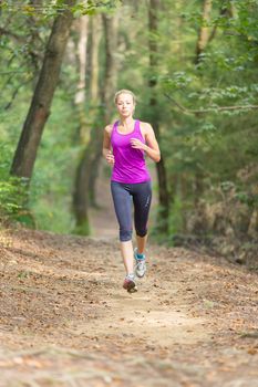 Pretty young girl runner in the forest.  Running woman. Female Runner Jogging during Outdoor Workout in a Nature. Beautiful fit Girl. Fitness model outdoors. Weight Loss. Healthy lifestyle. 