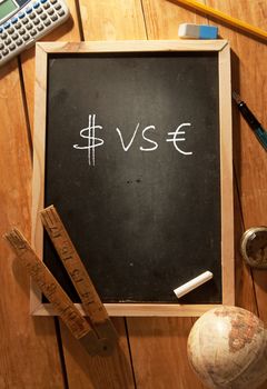 Dollar and euro symbol handwritten on a blackboard 