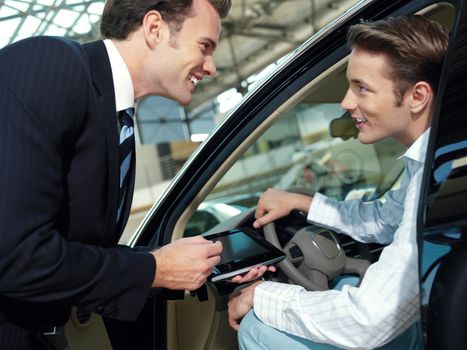 two serious businessmen with laptop in the car 