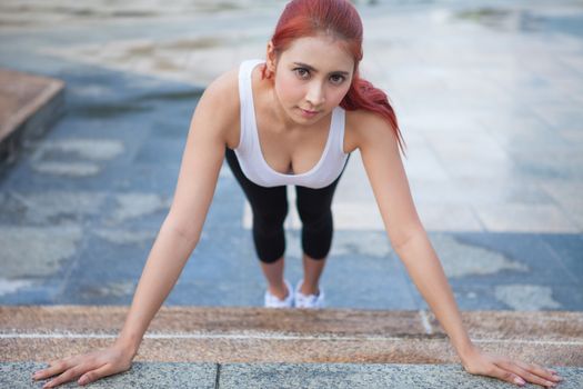 Beautiful young asian woman doing stretching exercise in the city
