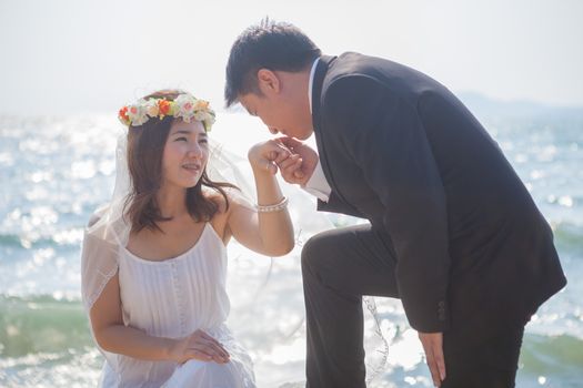 Beautiful asian couple on the beach in wedding dress