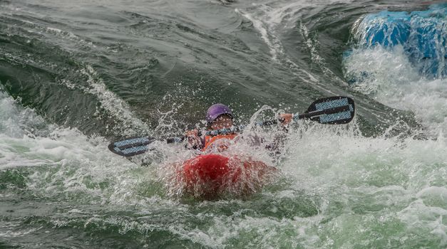 A single kayak, entering the rapids on a man made, white water course