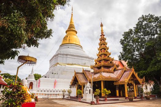 Ancient golden pagoda and myanmar style viharn at buddhist temple in lampang province, thailand