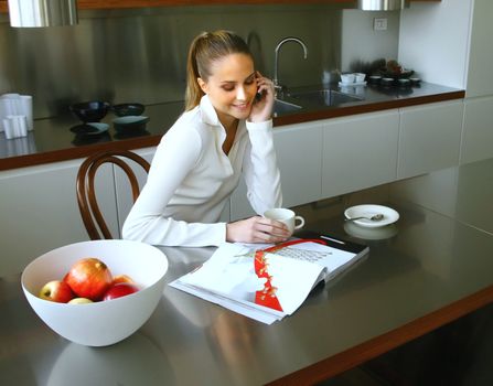 Happy middle woman enjoying a conversation while preparing a coffee