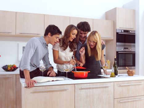 Group Of Young Friends Preparing Breakfast In Modern Kitchen 