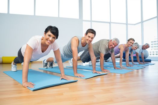 Fitness group doing push ups in row at the yoga class