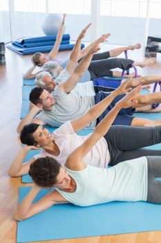 Fitness class stretching legs and hands in row at yoga class