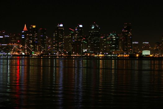 The skyline of San Diego at night with reflection in the water.