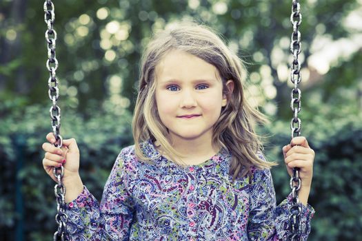 Girl on swing in summer park 