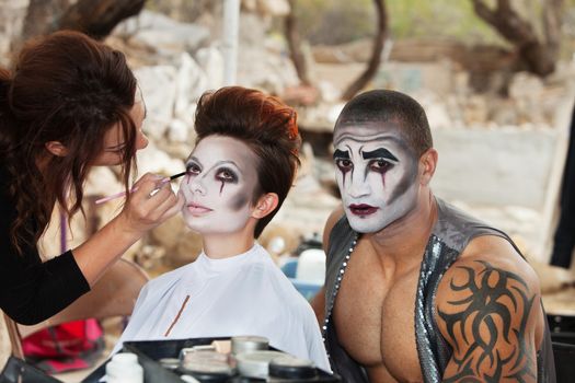 Makeup artist working clown eyeliner for performers