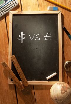 Dollar and british symbol handwritten on a blackboard 