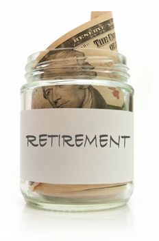 Glass jar filled with banknotes labeled with retirement
