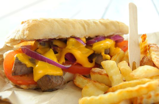 Melted cheese sandwich with beef steak and french fries 
