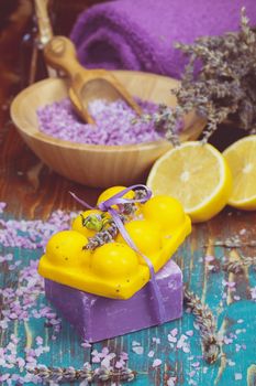 . Natural handmade lavender oil, soaps with bath salt, foaming bath bomb, lemon and lavender on wooden background. Macro, selective focus.