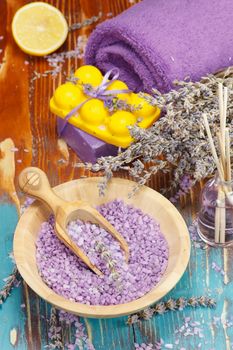 Natural handmade lavender oil, soap with bath salt, lemon and lavender on rustic wooden background. Macro, selective focus
