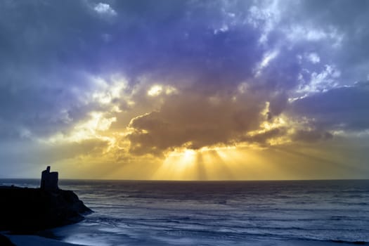 castle in Ballybunion county Kerry Ireland with beautiful beams shining through the clouds